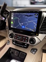 Car dashboard featuring a large touchscreen display with a navigation map and control buttons.