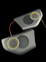 Two black audio speakers with yellow accents and mesh grilles connected by wires.