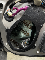 Open motorcycle speaker housing showing internal components and wiring connections.