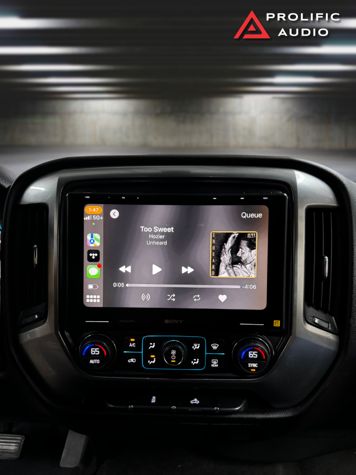 Front view of the Sony XAV-9500ES multimedia receiver installed in a 2014-2019 Chevrolet Silverado or GMC Sierra, displaying music playback on the dashboard.