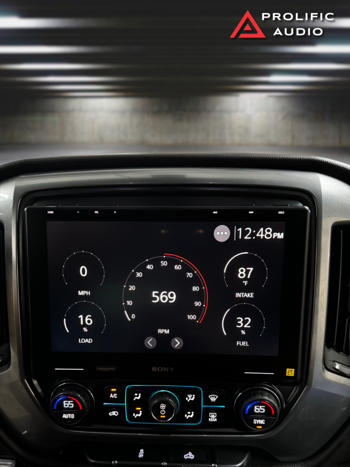 Sony XAV-9500ES multimedia receiver installed in a 2014-2019 Chevrolet Silverado or GMC Sierra showing performance gauges with RPM, speed, load, intake temperature, and fuel level.