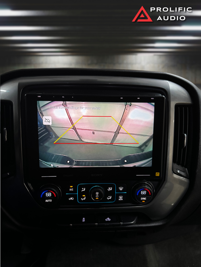 Sony XAV-9500ES installed in a 2014-2019 Chevrolet Silverado or GMC Sierra, showing a reverse camera display with parking guidelines for added safety.