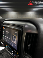 Side angle view of the Sony XAV-9500ES multimedia receiver installed in a 2014-2019 Chevrolet Silverado or GMC Sierra, displaying music playback on the dashboard using apple carplay.