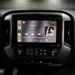 Black 10.1-inch touchscreen dash display with Sony XAV-9500ES showing media controls for a Chevrolet Silverado audio upgrade.