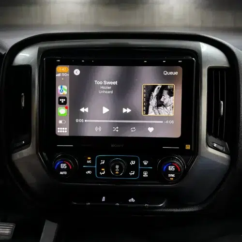 Black 10.1-inch touchscreen dash display with Sony XAV-9500ES showing media controls for a Chevrolet Silverado audio upgrade.