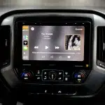 Black 10.1-inch touchscreen radio display showing music playback on the Sony XAV9500ES for 2014–2019 Chevy Silverado and GMC Sierra.