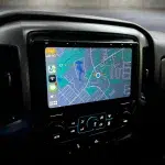 A Sony XAV9500ES 10.1" touchscreen in a black dash shows a navigation map for Chevrolet GMC Silverado Sierra.