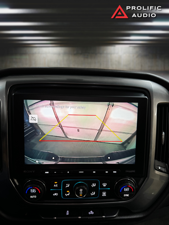 Rearview camera image displayed on the Sony XAV-AX8500 multimedia receiver installed in a 2014-2019 Chevrolet Silverado or GMC Sierra, showing parking guidelines and enhanced visibility.