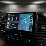 Car navigation screen showing a map with route options and search features.