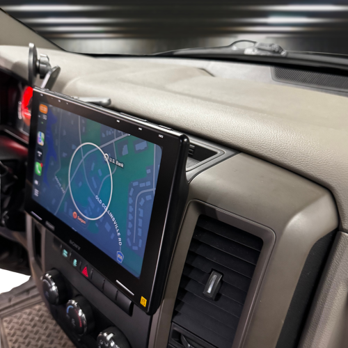 Car dashboard with a mounted touchscreen display showing a navigation map and control buttons.
