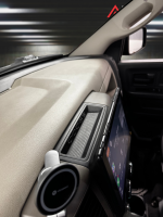 Interior view of a vehicle dashboard with a Dodge speaker and a touchscreen display mounted on the center console.