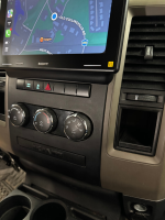 Dashboard of a vehicle showing a Sony display with navigation and climate control knobs.