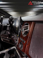 Interior view of a car dashboard featuring a touchscreen display and wooden accents from Prolific Audio.