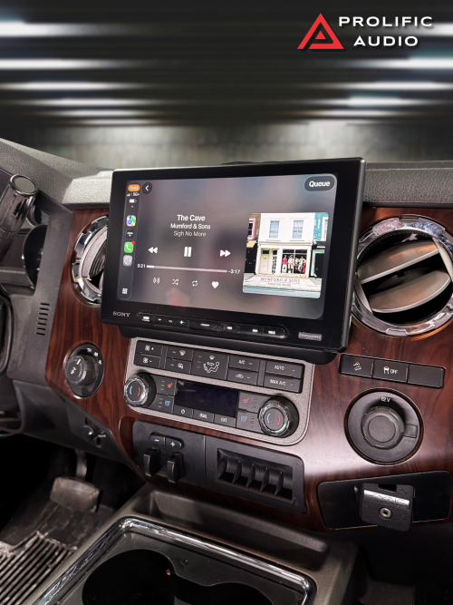 Car dashboard with a Sony multimedia display showing music playback and climate controls.